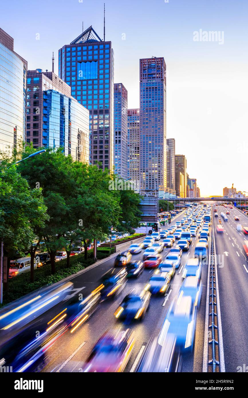 Trafficata strada della città e grattacieli edifici a Pechino al tramonto, Cina. Foto Stock