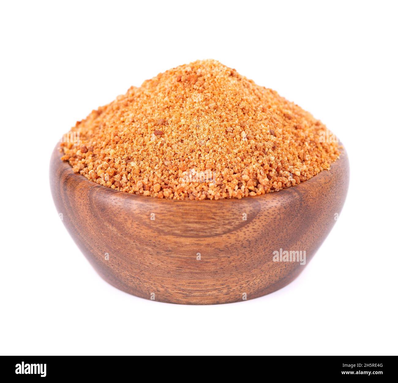 Zucchero di cocco isolato su sfondo bianco. Far rosolare lo zucchero di palma di cocco non raffinato in una ciotola di legno Foto Stock