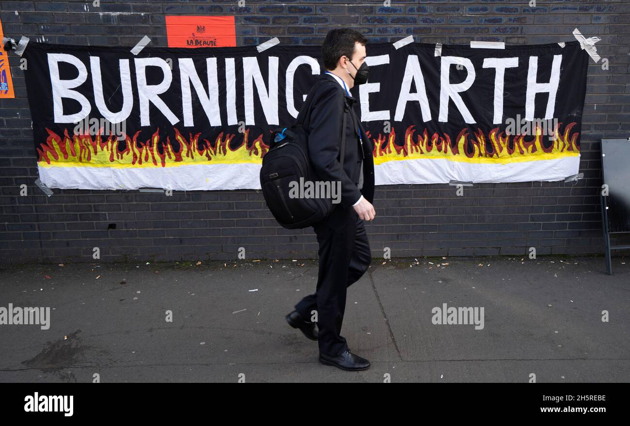 Glasgow, Scozia, Regno Unito. 11 novembre 2021. 12° giorno del vertice sul clima di UM COP26 a Glasgow. PIC; membro del pubblico cammina oltre il banner di protesta sul cambiamento climatico. Iain Masterton/Alamy Live News. Foto Stock