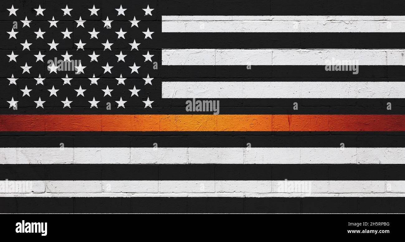 La bandiera americana dipinse su un muro di mattoni in bianco e nero con una striscia arancione. Foto Stock