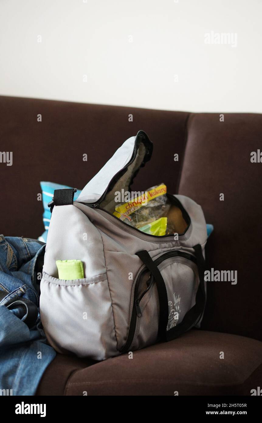 SARBINOWO, POLONIA - Nov 13, 2015: Una borsa di materiale riempita di cibo per bambini e attrezzature che si stendono su un divano Foto Stock