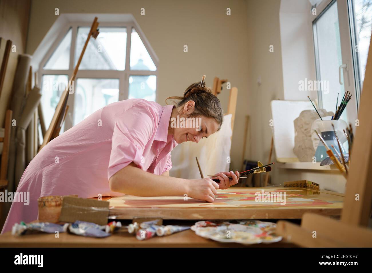 Arte, creatività, hobby e concetto di occupazione creativa. Dare vita alla creatività. Donna pittura in studio d'arte. Pittura femminile attraente Foto Stock