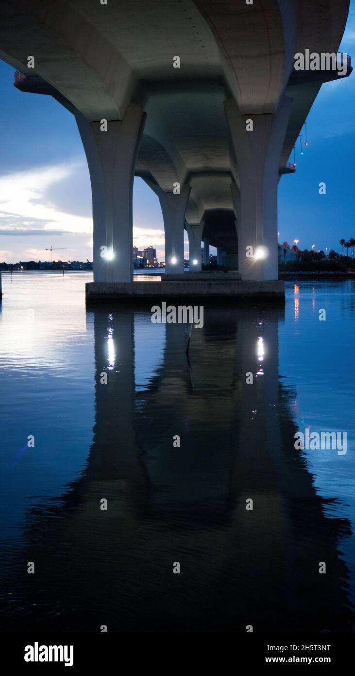 La parte inferiore di un ponte mentre il sole corre e la notte cade. Splendidi riflessi sulle migliori attrazioni di Tampa Bay. Foto Stock