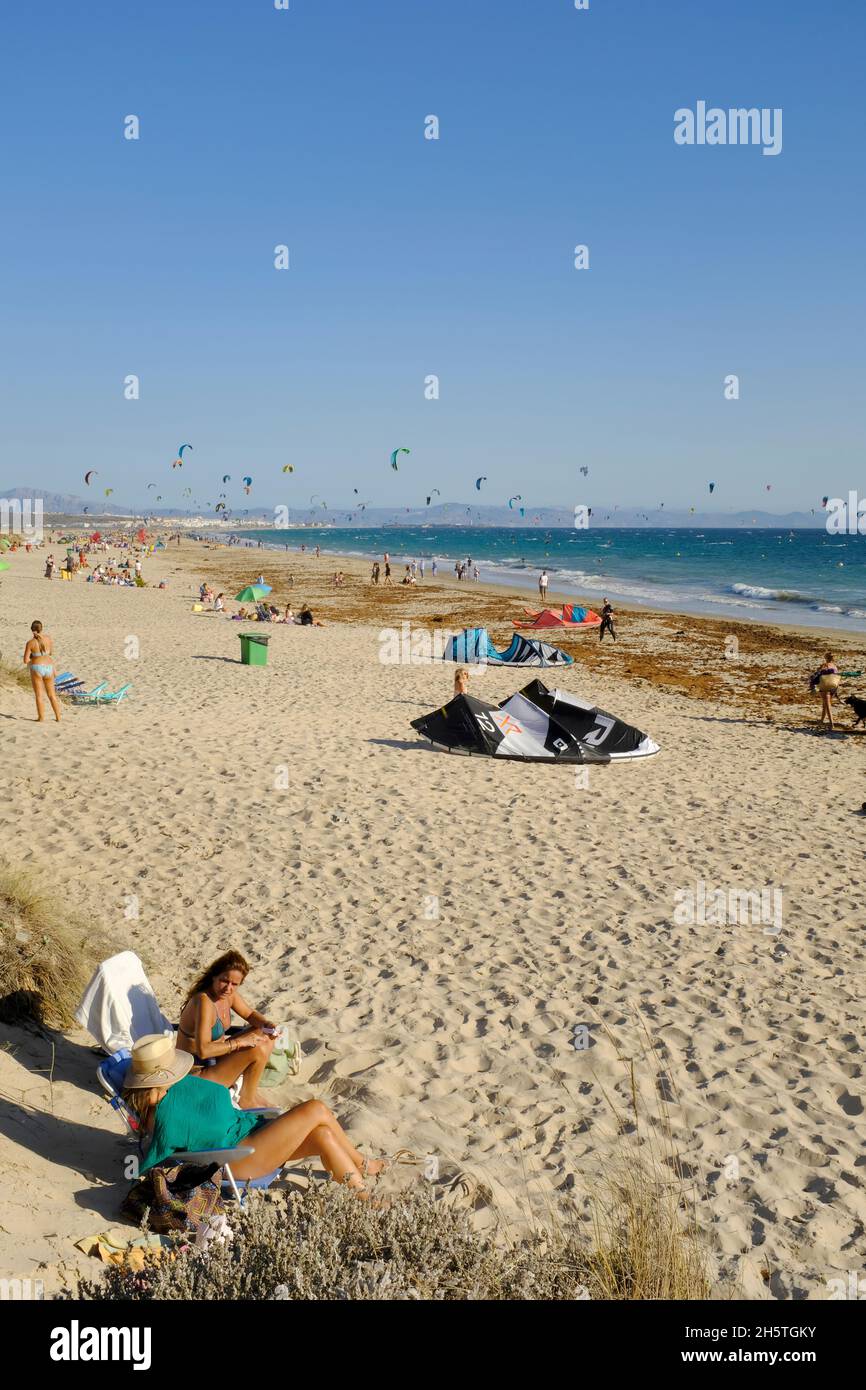 Kitesurfers e sunbathers sulla spiaggia di Los Lances. Tarifa, Costa de la Luz, Provincia di Cadice, Andalusia, Spagna Foto Stock