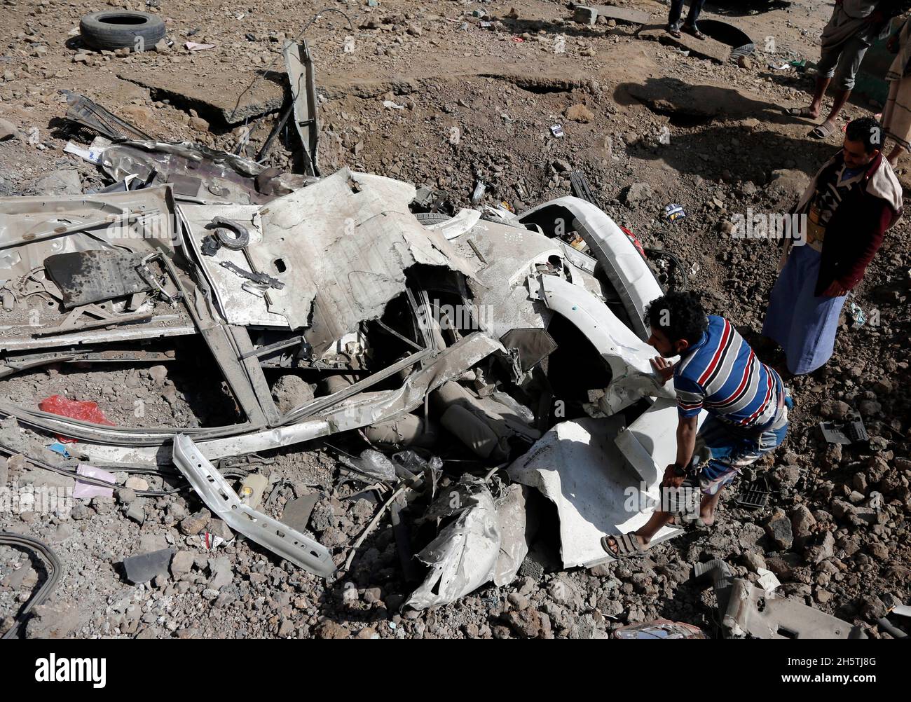 Sanaa, Yemen. 11 Nov 2021. I residenti locali si trovano nei pressi di veicoli distrutti in un quartiere di Sanaa, Yemen, il 11 novembre 2021. I piani di guerra della coalizione a guida Saudita hanno lanciato diversi attacchi aerei su campi militari controllati dalla milizia Houthi all'interno e intorno alla capitale dello Yemen Sanaa all'inizio di giovedì mattina, Houthi-run al-Masirah TV ha riferito. Credit: Nyooooooooooooooooooooooooooooo Foto Stock