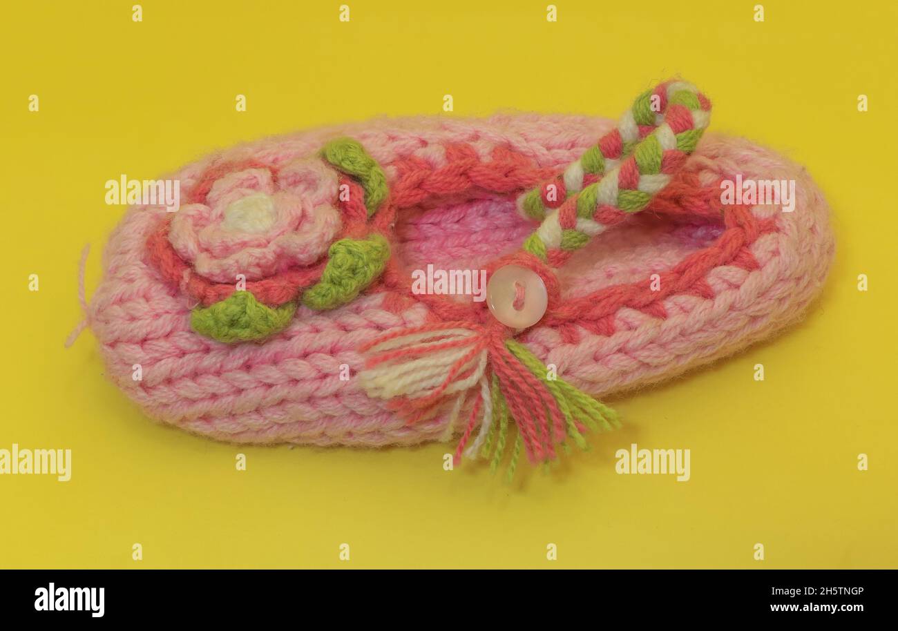 Calza rosa per bambini in lana su sfondo giallo Foto Stock