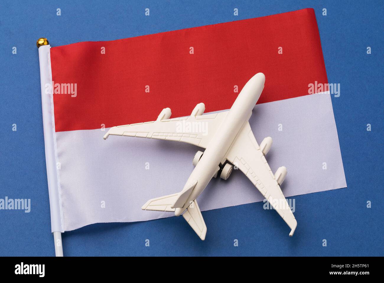 Bandiera della Polonia e un aereo giocattolo su sfondo blu, il concetto sul tema del viaggio in Polonia Foto Stock
