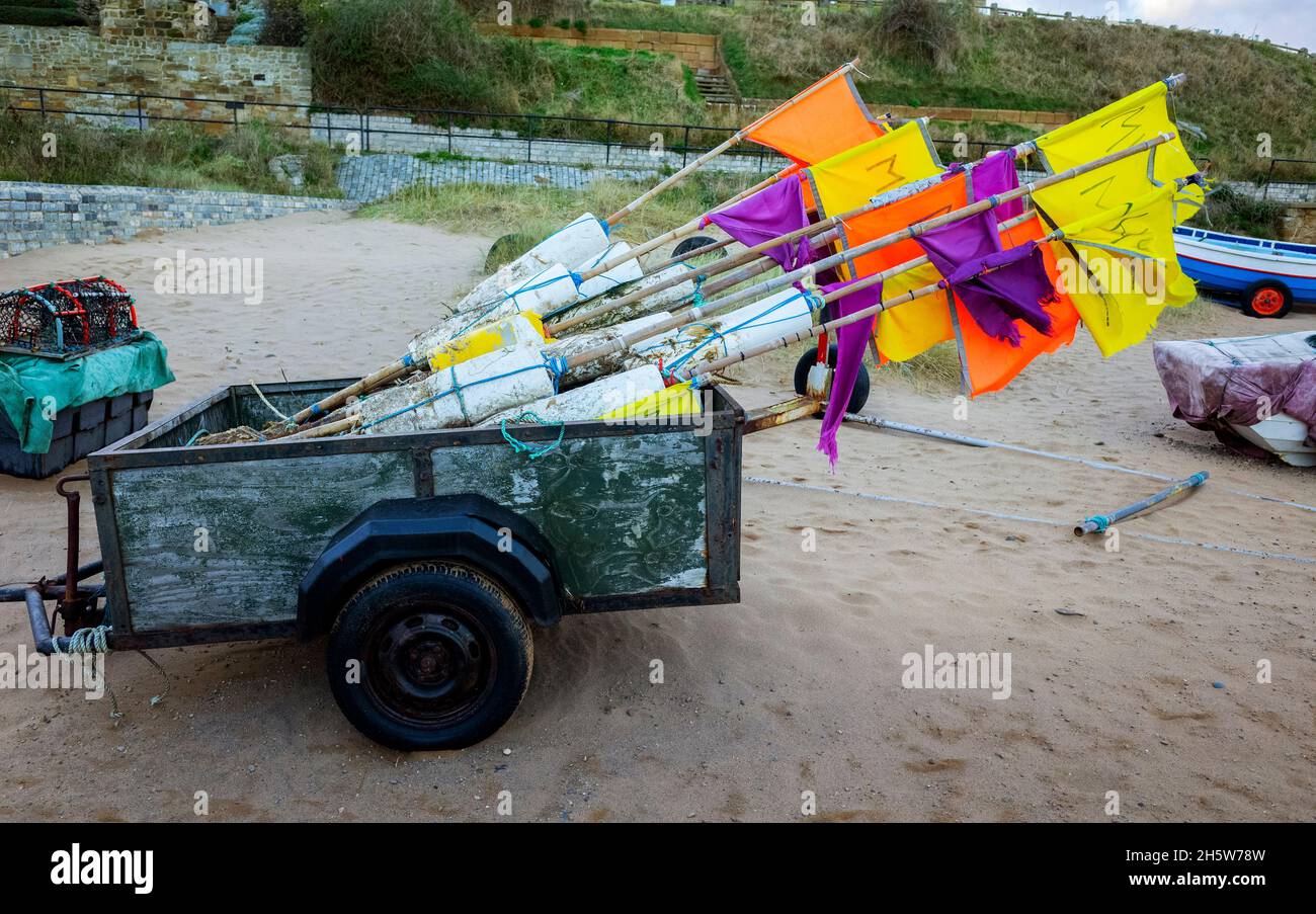 Un rimorchio pieno di boe con bandiere per marcare la posizione di aragosta o granchio pentole quando questi sono in uso in mare a Marske dal mare North Yorkshire Foto Stock
