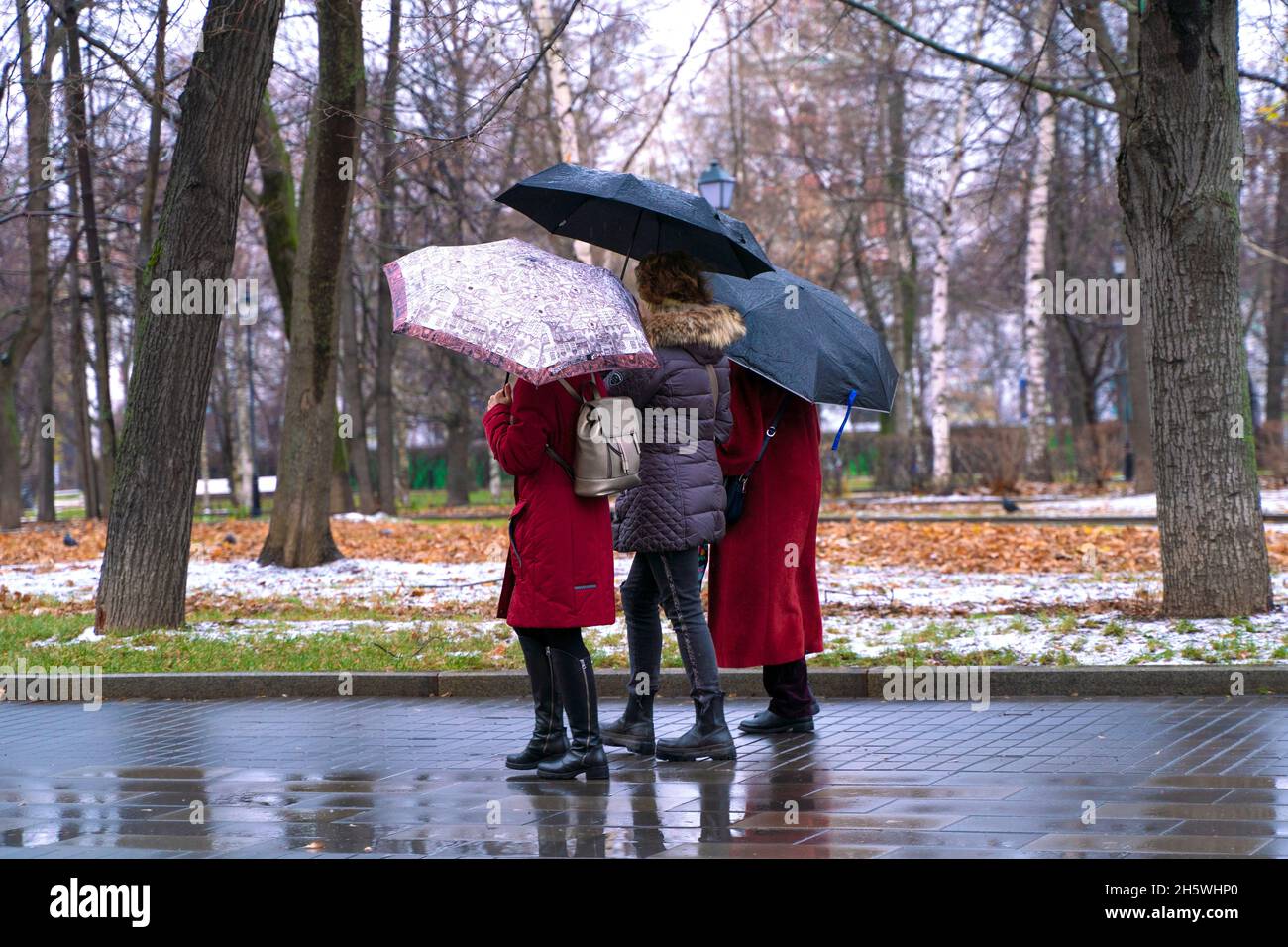 Mosca, Russia - 11 novembre 2021: Pioggia in città, donna con ombrello a piedi su una strada su folla di gente sfondo. Tempo piovoso, tempesta autunnale. Foto di alta qualità Foto Stock