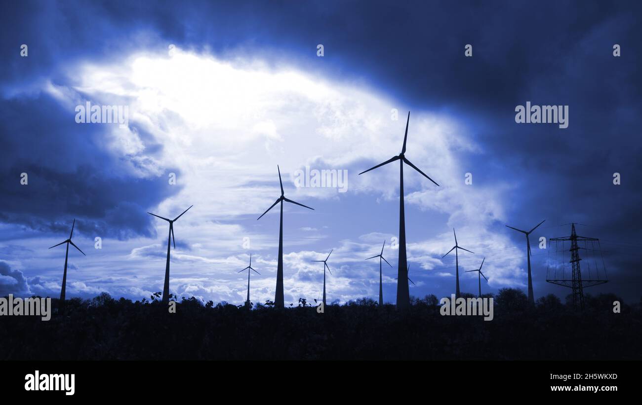 mulini a vento che producono elettricità in un cielo blu scuro Foto Stock