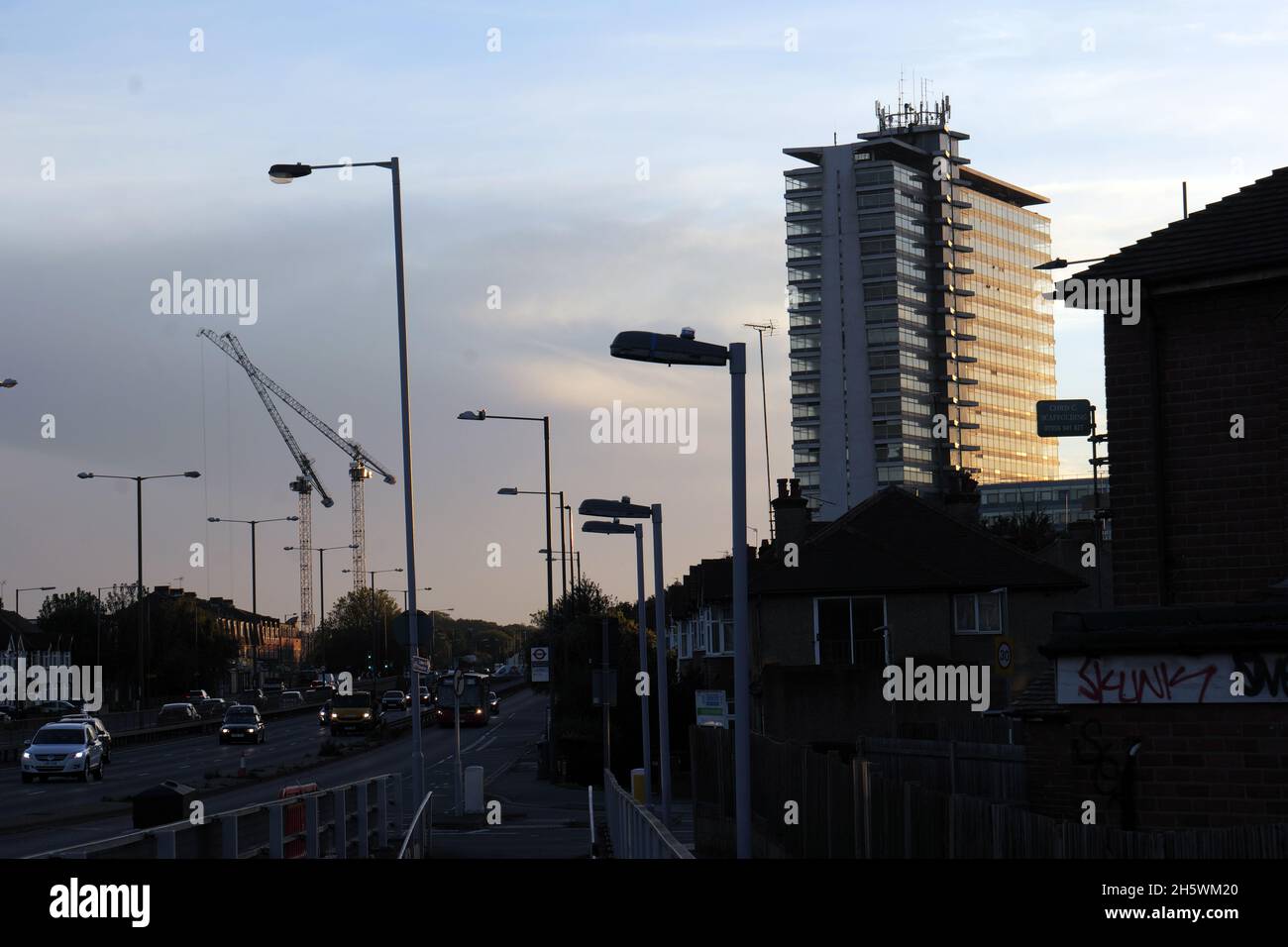 Traffico pesante sulla circonvallazione A3 con Tolworth Tower in silhouette al tramonto con traffico in prima serata. Foto Stock