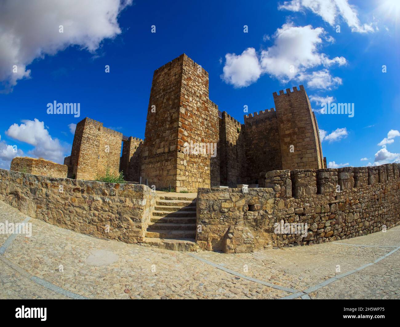 Facciata d'ingresso al castello di Trujillo a Cáceres in una giornata di cielo blu con le nuvole Foto Stock