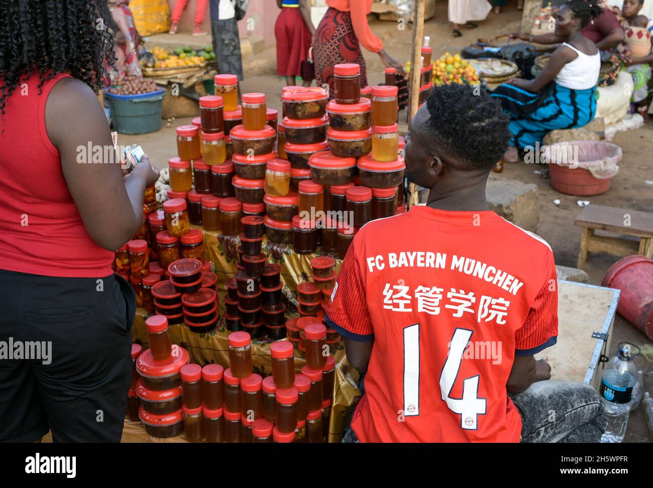 Malawi, Lilongwe, mercato nella città vecchia, miele venditore in FC Baviera Monaco di camicia, made in China / Markt in der Altstadt, Honig Verkäufer im FC Bayern München Trikot, made in China Foto Stock