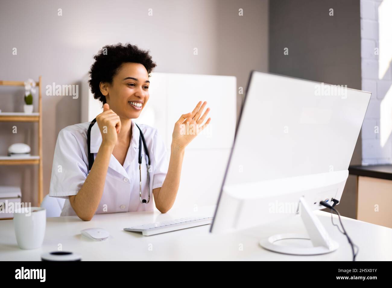 contento medico infermiera chat in linea con paziente su il computer  portatile durante telemedicina verifica appuntamento. gioioso asiatico  donna indossare protettivo viso maschera utilizzando gadget, isolato al di  sopra di blu studio