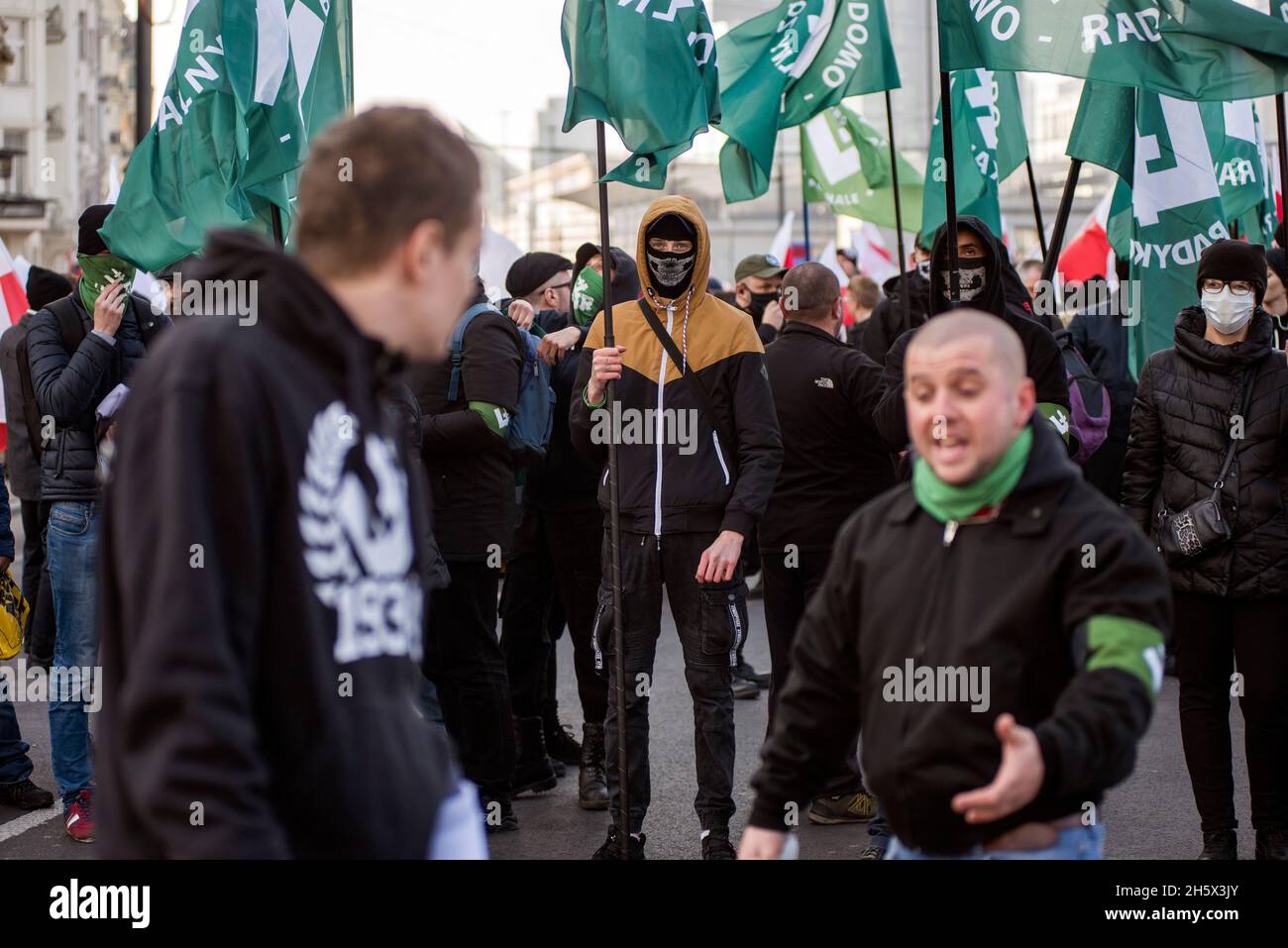 Varsavia, Polonia. 11 Nov 2021. Un nazionalista mascherato detiene la bandiera del National Radical Camp (ONR) durante il marzo.la Giornata Nazionale dell'Indipendenza della Polonia segna l'anniversario dell'indipendenza del Paese nel 1918. Il 11 novembre di ogni anno viene festeggiata a livello nazionale. Anche quest'anno decine di migliaia di polacchi hanno partecipato alla marcia della Giornata dell'Indipendenza a Varsavia organizzata da organizzazioni di estrema destra per celebrare il 103° anniversario della rinascita della Polonia come Stato indipendente. Lo slogan della marcia era: "L'indipendenza non è in vendita!". (Foto di Attila Husejnow/SOPA Images/Sipa USA) Cr Foto Stock