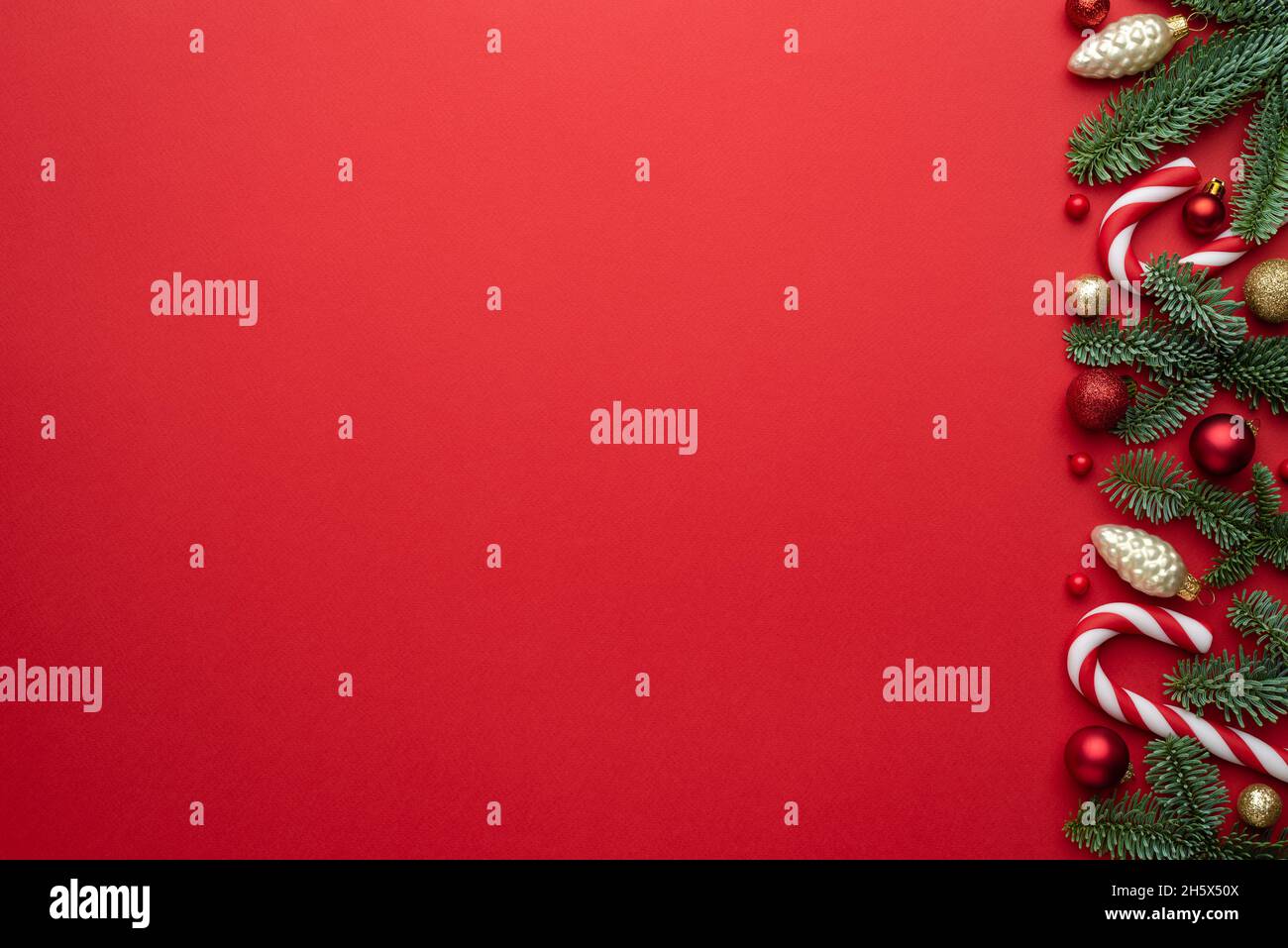 Sfondo rosso di Natale con rami di abete e decorazioni. Banner di Capodanno con spazio per la copia. Vista dall'alto, piatto Foto Stock