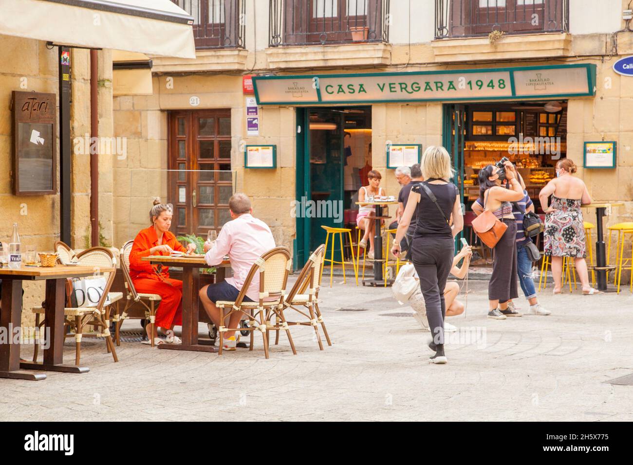 Persone che si siedono mangiare e bere all'aperto presso i tapas bar nella località balneare spagnola di San Sebastian, nella baia di Biscay Cantabria Spagna Foto Stock