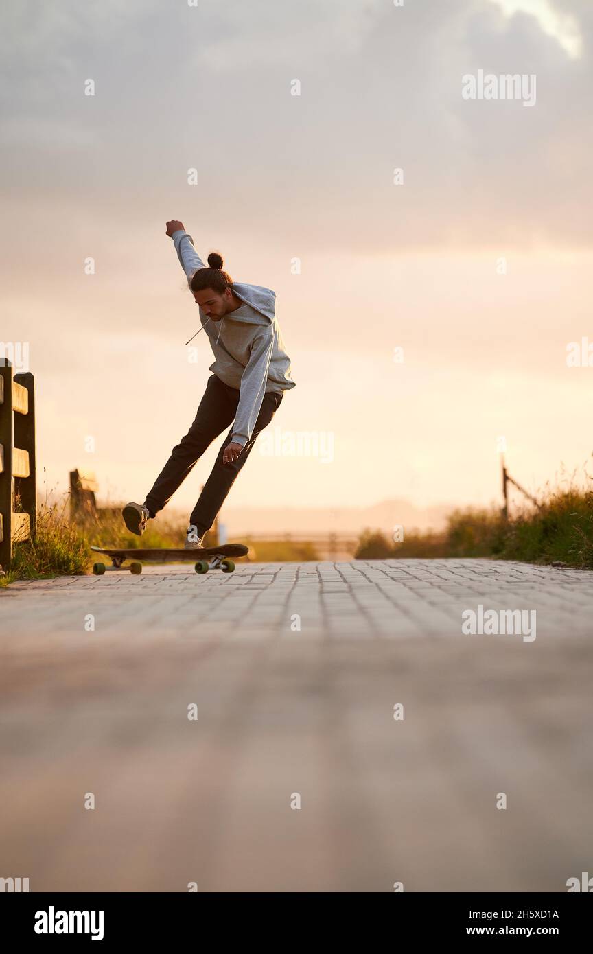 Crop anonimo confettioner femminile in grembiule e guanti preparazione deliziosa dolce decorato con cioccolato commestibile colorato in camera luminosa Foto Stock