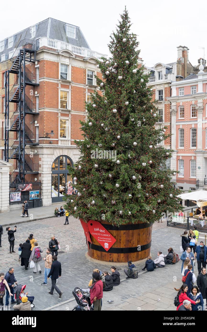 Albero di Natale gigante decorato con bolle e nastri a Covent Garden Square, i turisti godono l'atmosfera del festival nel West End di Londra Inghilterra Regno Unito Foto Stock