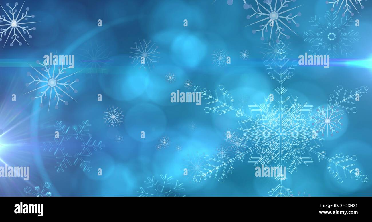 Immagine di fiocchi di neve di natale che cadono su sfondo blu bokeh Foto Stock