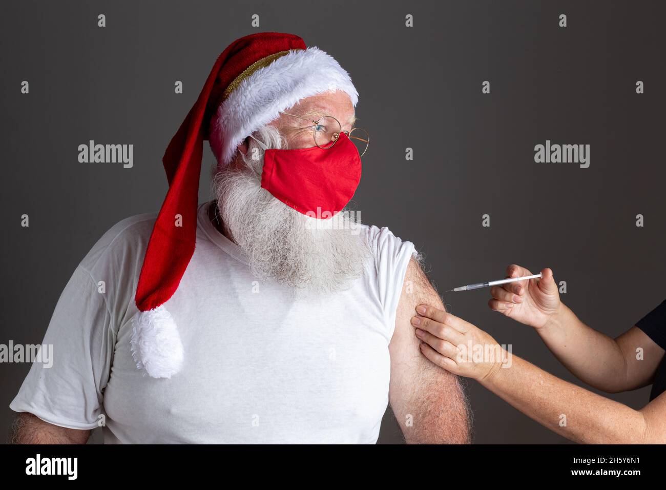 Babbo Natale indossare maschera viso essere vaccinato con l'iniezione Foto  stock - Alamy