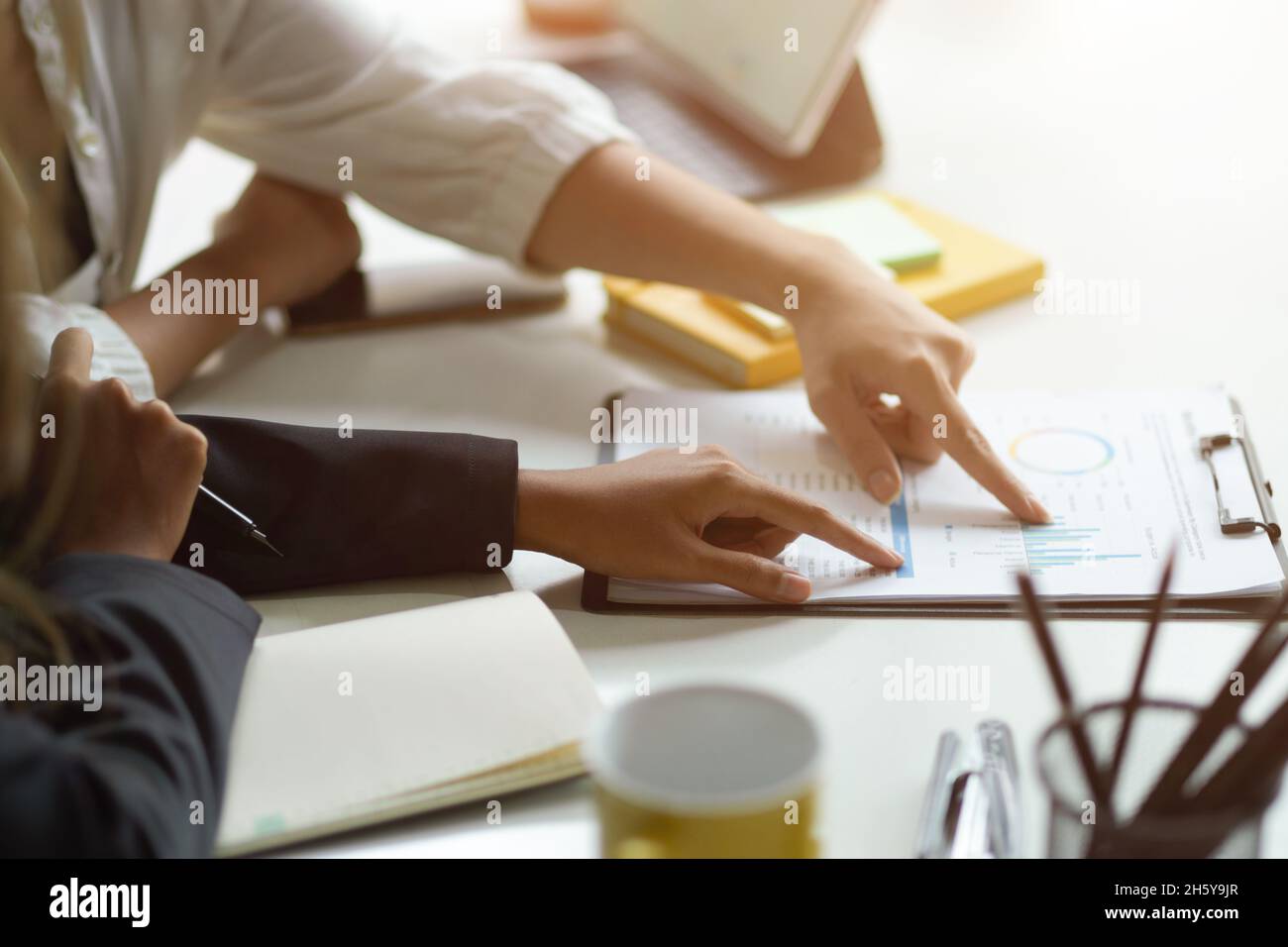 Scatto corto dei businessspeople in un team di consulente finanziario che vota sul programma migliore per la loro azienda. Dito che punta sul rapporto. Foto Stock