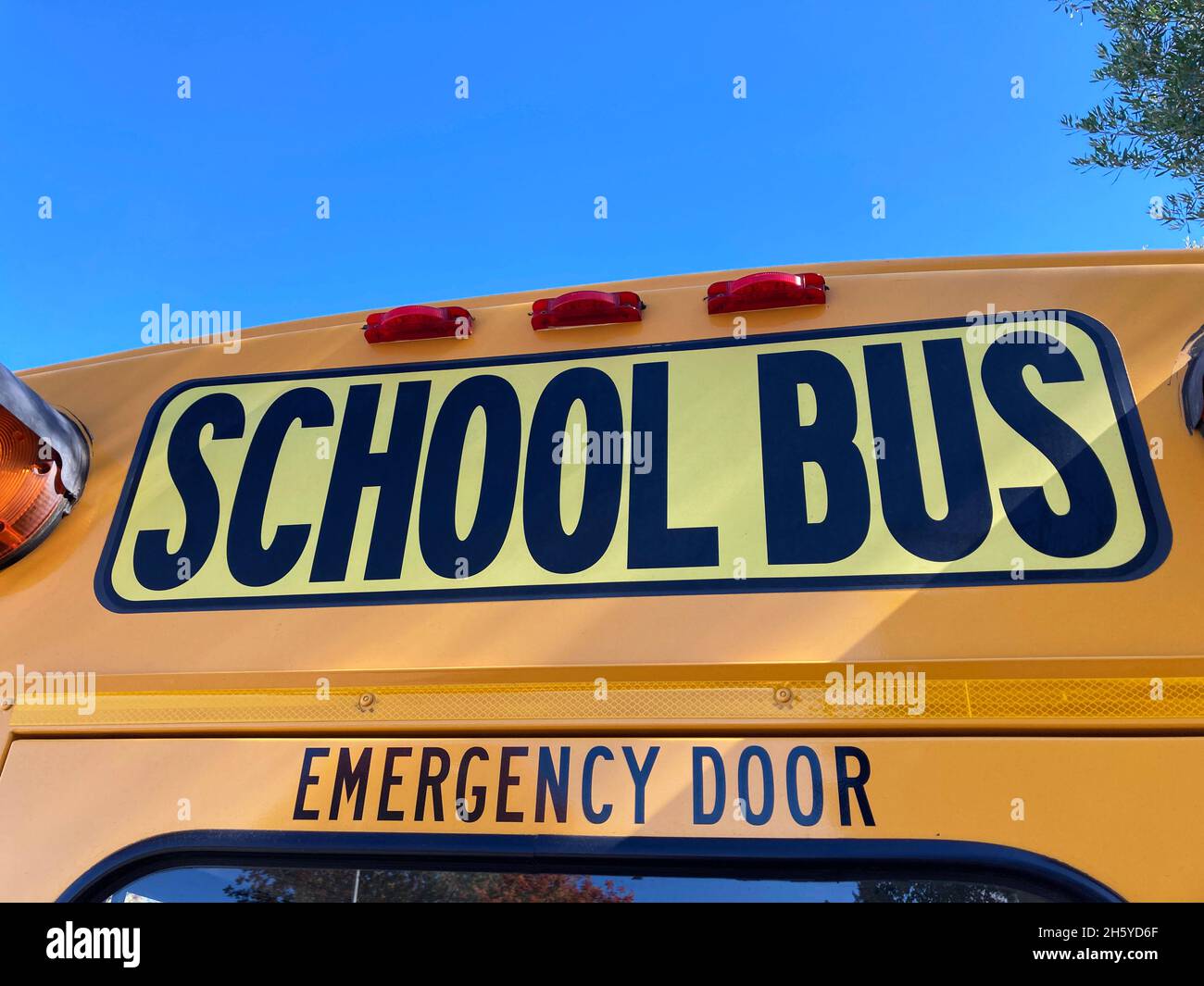 Segnale scuolabus sopra la porta di uscita di emergenza posteriore. Primo piano Foto Stock