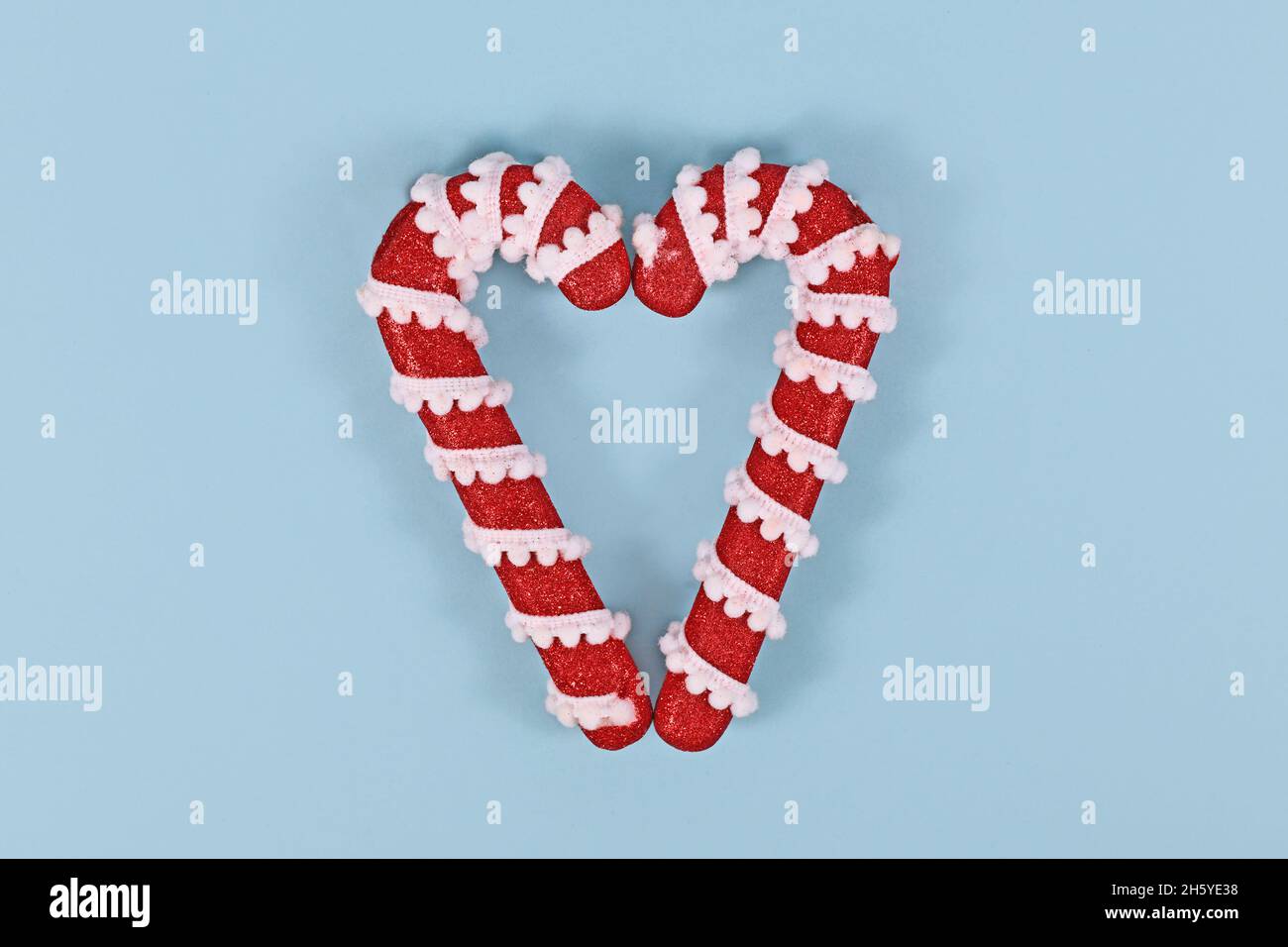 Due ornamenti natalizi di canna di caramella che formano la forma del cuore Foto Stock