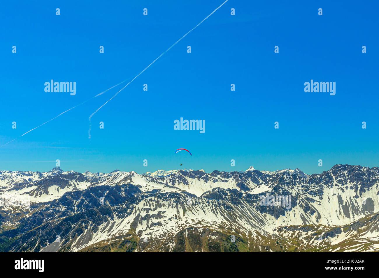 Parapendio in montagna nel cielo blu del picco di Aroser Weisshorn, località turistica in Svizzera. Vista dall'alto della stazione della funivia di Plessur Alps in Foto Stock