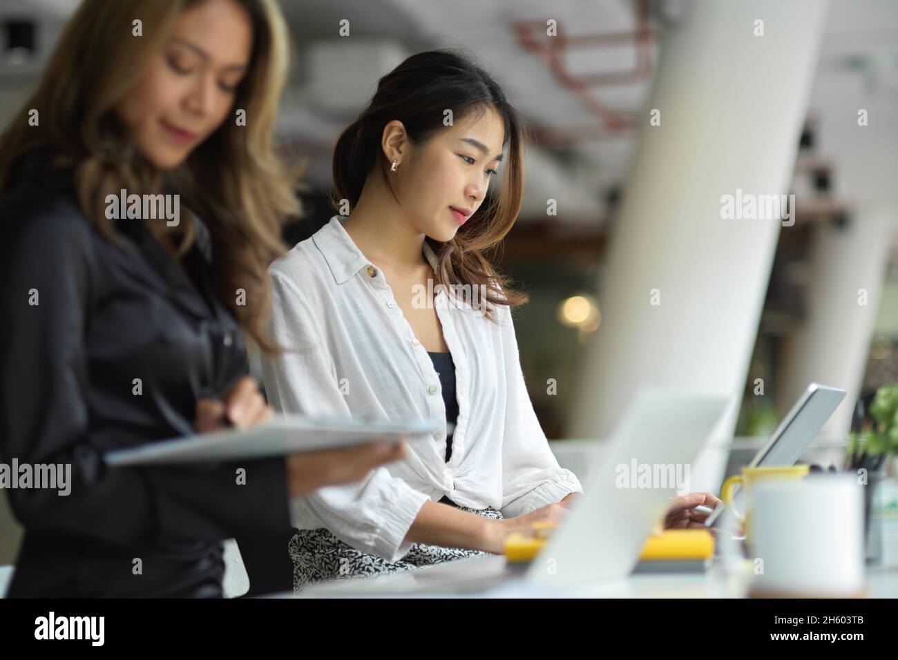 Le donne d'affari ragionieri che lavorano al loro computer portatile, collaborando al progetto di strategie aziendali. Foto Stock