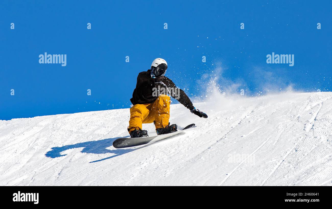 Snowboarder in azione in pista con neve fresca Foto Stock