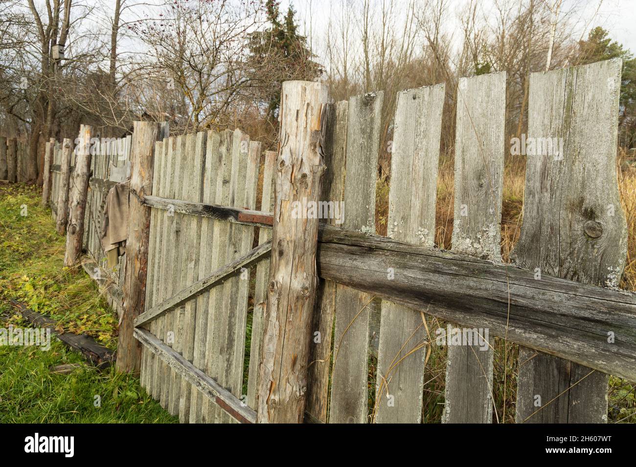 Recinzione in legno con un palo leggermente askew sul suo lato in campagna Foto Stock