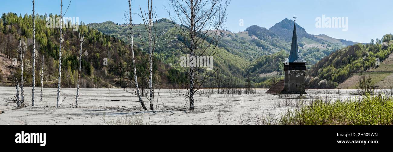 Chiesa abbandonata allagata da un lago pieno di acqua contaminata. Geamana, Rosia Montana. Lago inquinato in montagna da una miniera in Romania Foto Stock