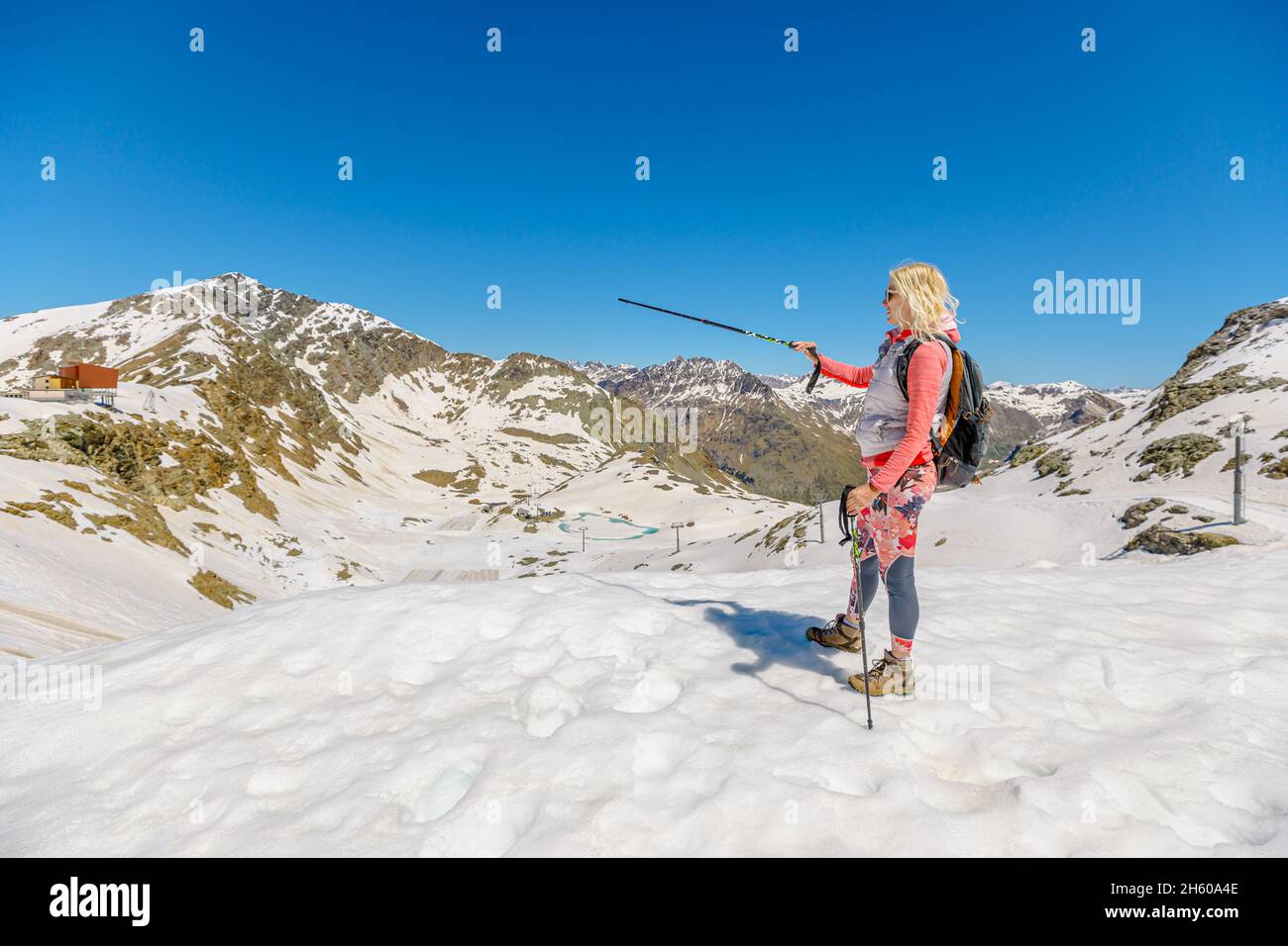 Ragazza che cammina al tramonto con racchette da trekking sulla cima del col Diavolezza. Monte pers e Piz Trovat Svizzera nel cantone di Graubunden. Foto Stock