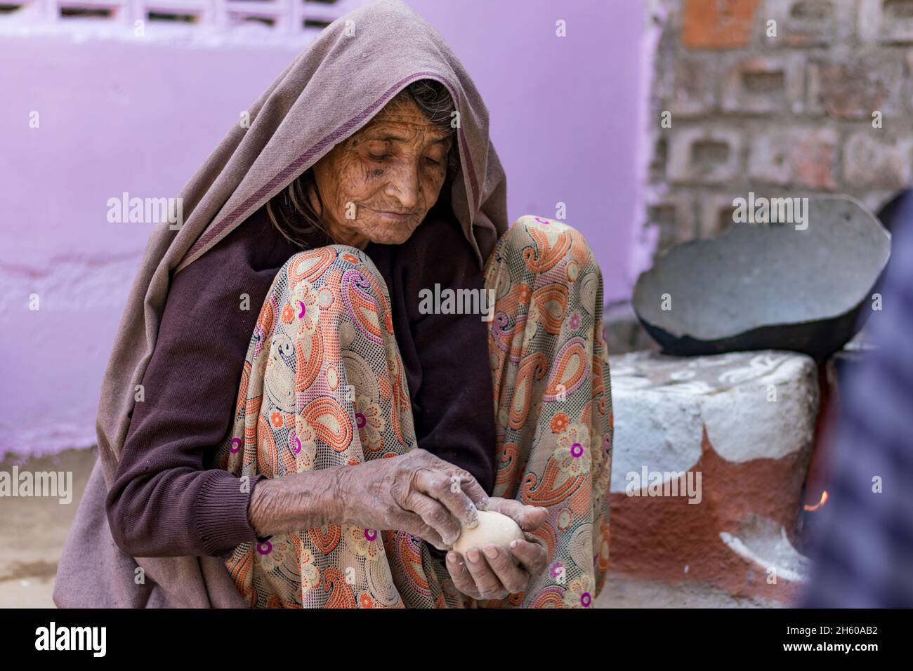 una donna indiana di vecchiaia che fa il cibo per la famiglia in rajasthan, india Foto Stock