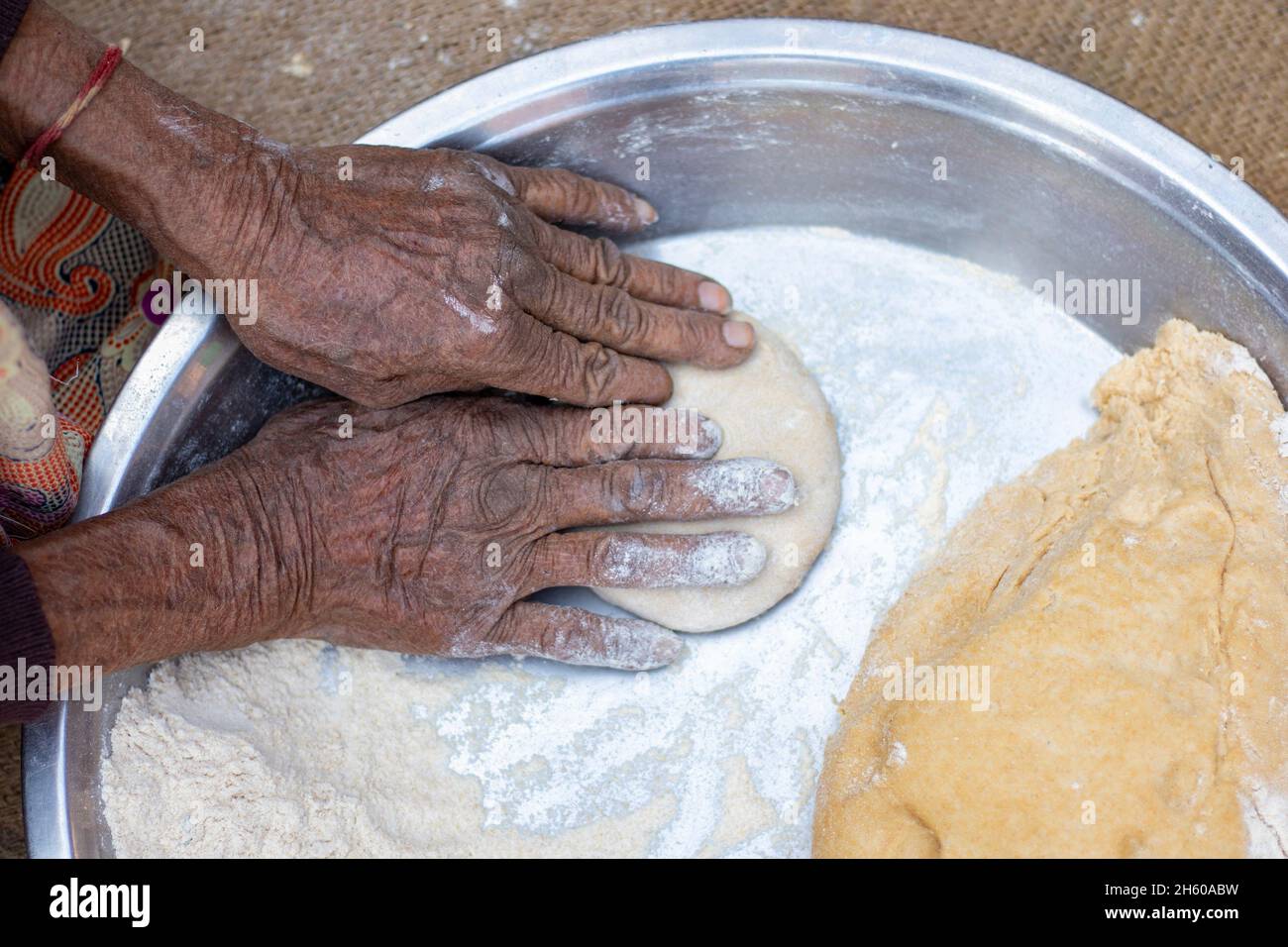 Donna anziana mano facendo chapati. Foto Stock