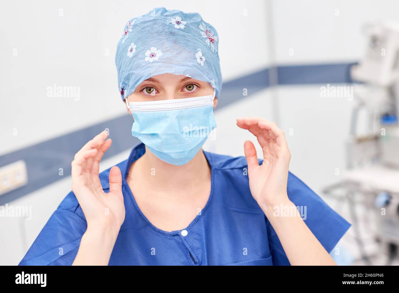 Giovane donna come chirurgo o infermiere della sala operatoria con maschera facciale e mani sterili prima dell'intervento Foto Stock