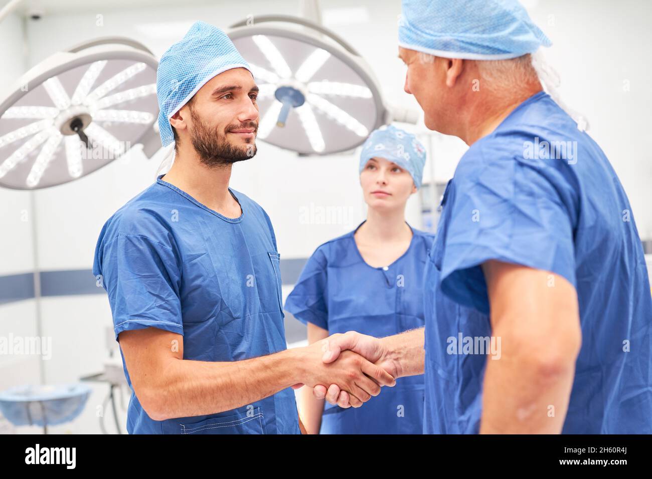Due chirurghi si stringono a mano dopo un'operazione per la cooperazione e le congratulazioni Foto Stock