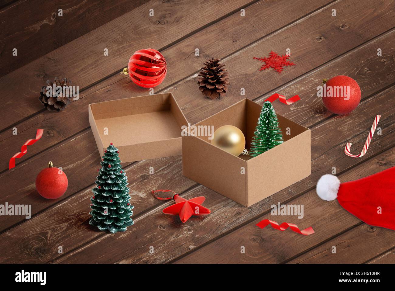 Togliendo le decorazioni di Natale dalla scatola. Preparazioni per decorare l'albero di Natale e concetto di spazio domestico. Vista isometrica Foto Stock