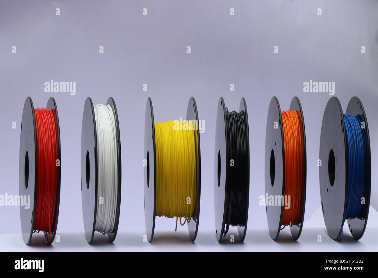 I filamenti PLA sono uno dei materiali di stampa 3d, bobine di filamenti plastici di colore diverso isolate su bianco Foto Stock
