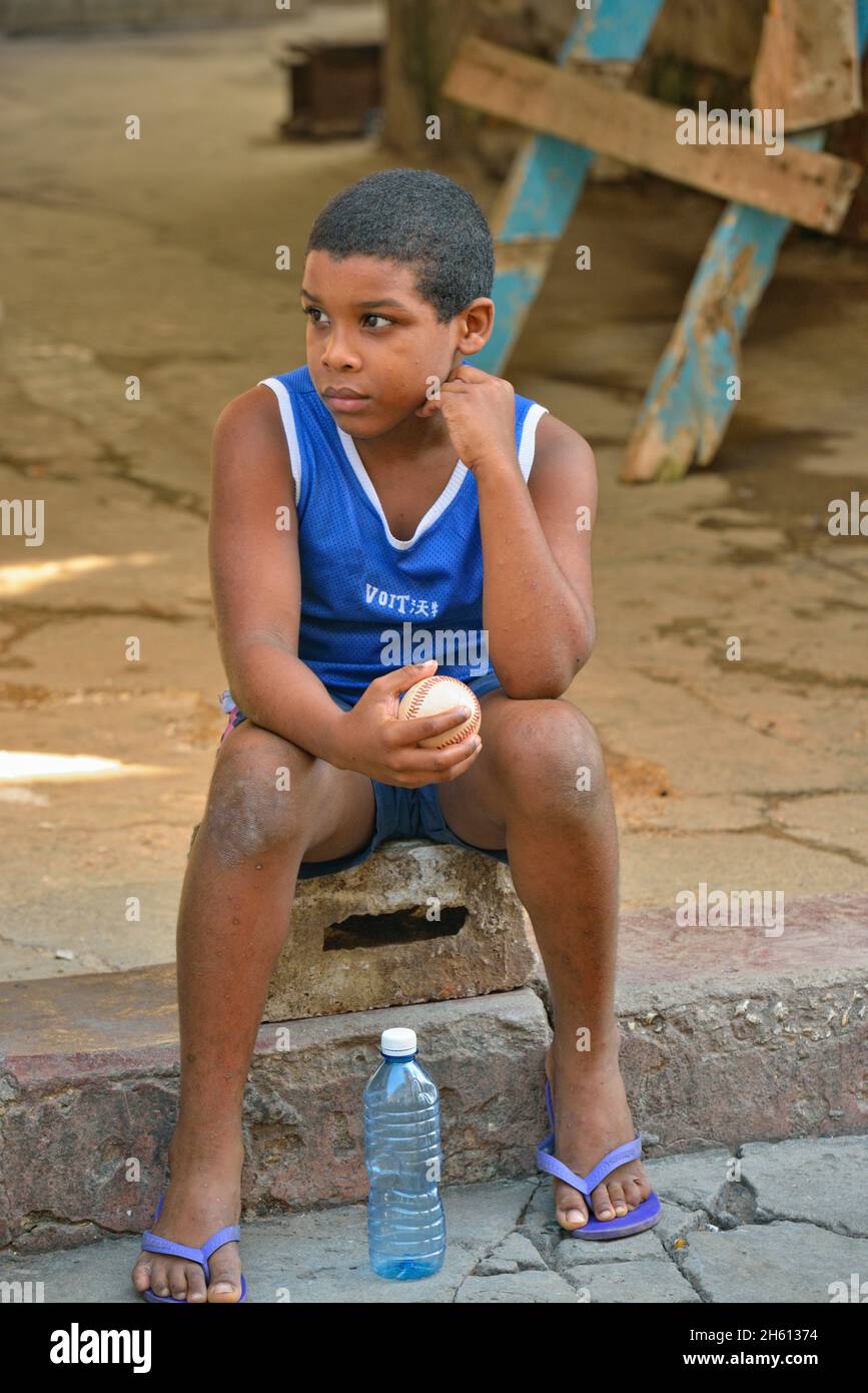 Scena di strada in Old Havana- un ragazzo con un baseball, la Habana (l'Avana), Habana, Cuba Foto Stock