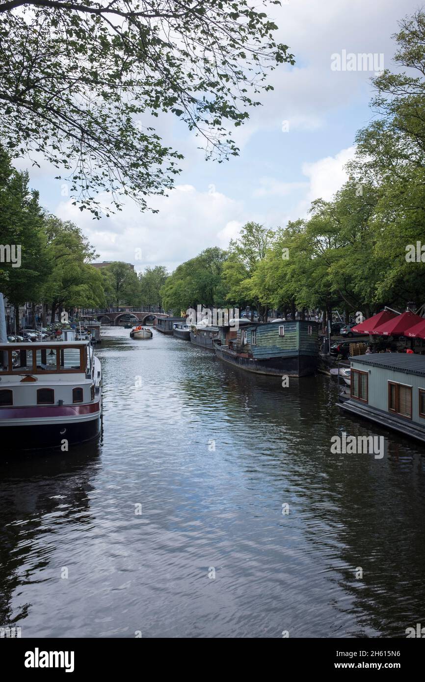 Case galleggianti ormeggiate lungo un canale nel centro di Amsterdam, Paesi Bassi. Con il 50 per cento dei Paesi Bassi al di sotto del livello del mare, è incredibilmente vulnerabile all'aumento del livello del mare provocato dai cambiamenti climatici. Essa limita anche la quantità di spazio abitabile per le persone e si devono trovare soluzioni alternative. Foto Stock