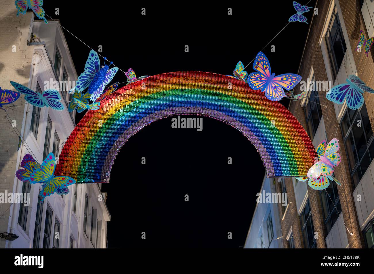 LONDRA - 1 NOVEMBRE 2021: Arcobaleno colorato e decorazioni a farfalla sospeso sopra Carnaby Street per Natale Foto Stock