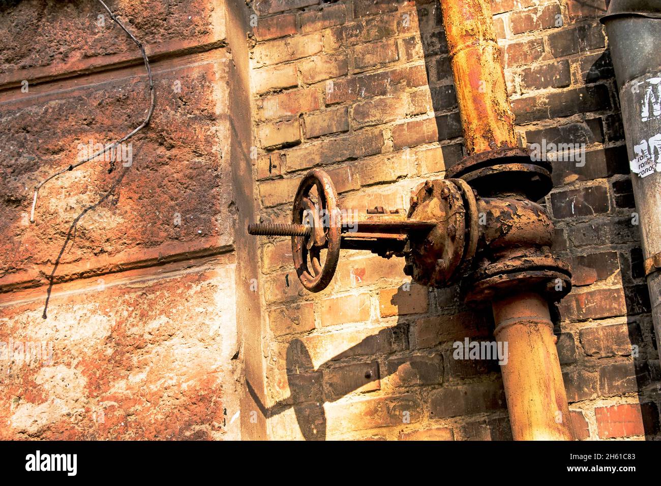 Vecchia valvola di controllo del gas arrugginito sulla parete. Una valvola industriale in un sistema di grandi dimensioni. Il sistema di trasmissione del gas ucraino sta fallendo. Foto Stock