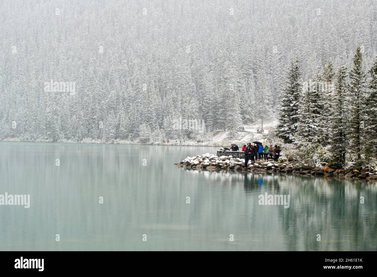 I visitatori del lago Louise in una tempesta di neve a fine estate, Banff National Park, Alberta, Canada Foto Stock