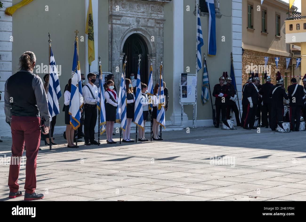 Lefkada. Grecia. 10.28.2021. Bambini greci che detengono la bandiera nazionale prima del servizio della chiesa in occasione della celebrazione del giorno di Oxi. Foto Stock