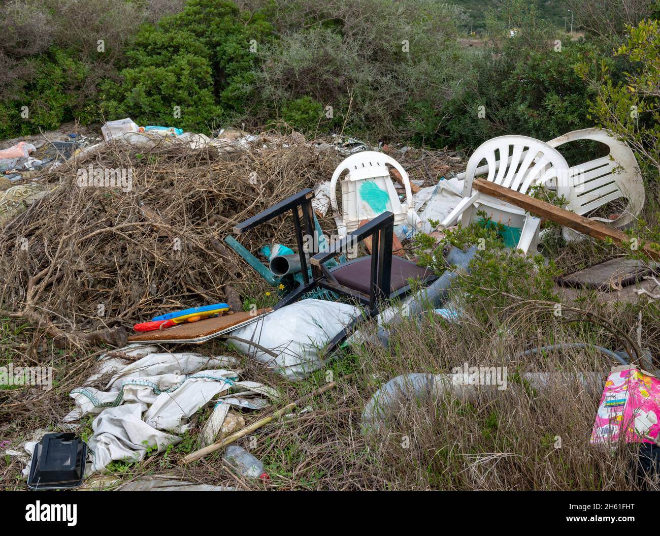 Lo scarico illegale di rifiuti che causano danni ambientali alla campagna. Foto Stock