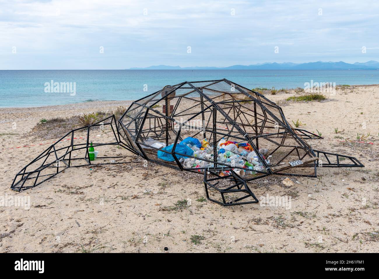 Lefkada. Grecia-10.26.2021. Una scultura di una tartaruga su una spiaggia con interno plastico che trasmette un messaggio ambientale di inquinamento marino plastico. Foto Stock