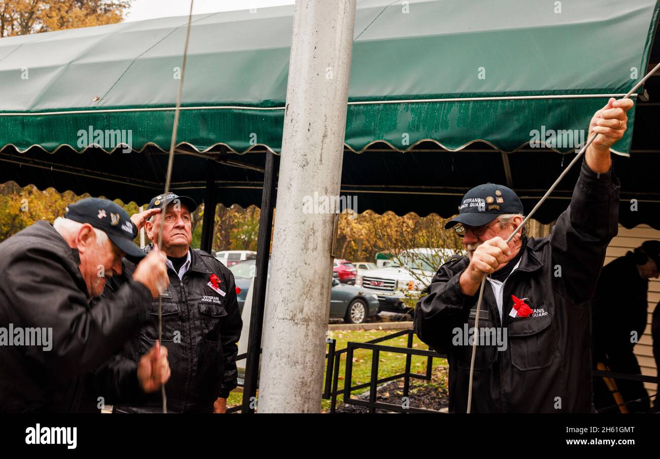 BLOOMINGTON, STATI UNITI D'AMERICA - 2021/11/11: I membri della guardia d'onore alzano la bandiera americana dopo una cerimonia di Veterans Day tenutasi al Burton Woolery American Legion Post 18, giovedì 11 novembre 2021 a Bloomington, Ind. (Foto di Jeremy Hogan/The Bloomingtonian) Foto Stock