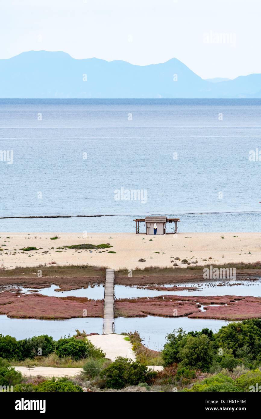 Vista aerea di una palude di sale con un ponte di legno che conduce ad una riva di sabbia fino al mare. Un paradiso per la fauna selvatica. Foto Stock